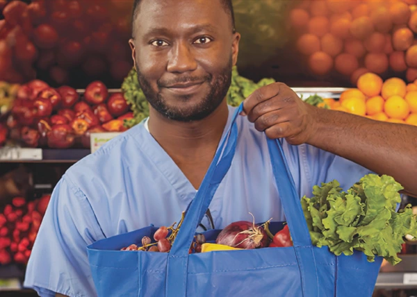 image of a healthcare worker with a bag full of fresh produce