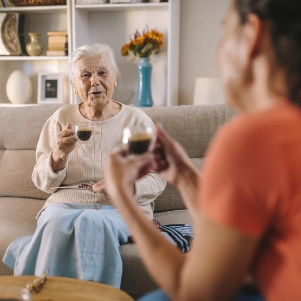 Shot of an elderly woman and her daughter having a chat over coffee on the sofa at home